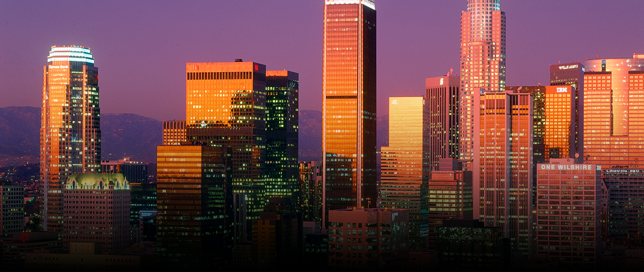 City skyline illuminated by sunset, creating a stunning view of buildings and lights.