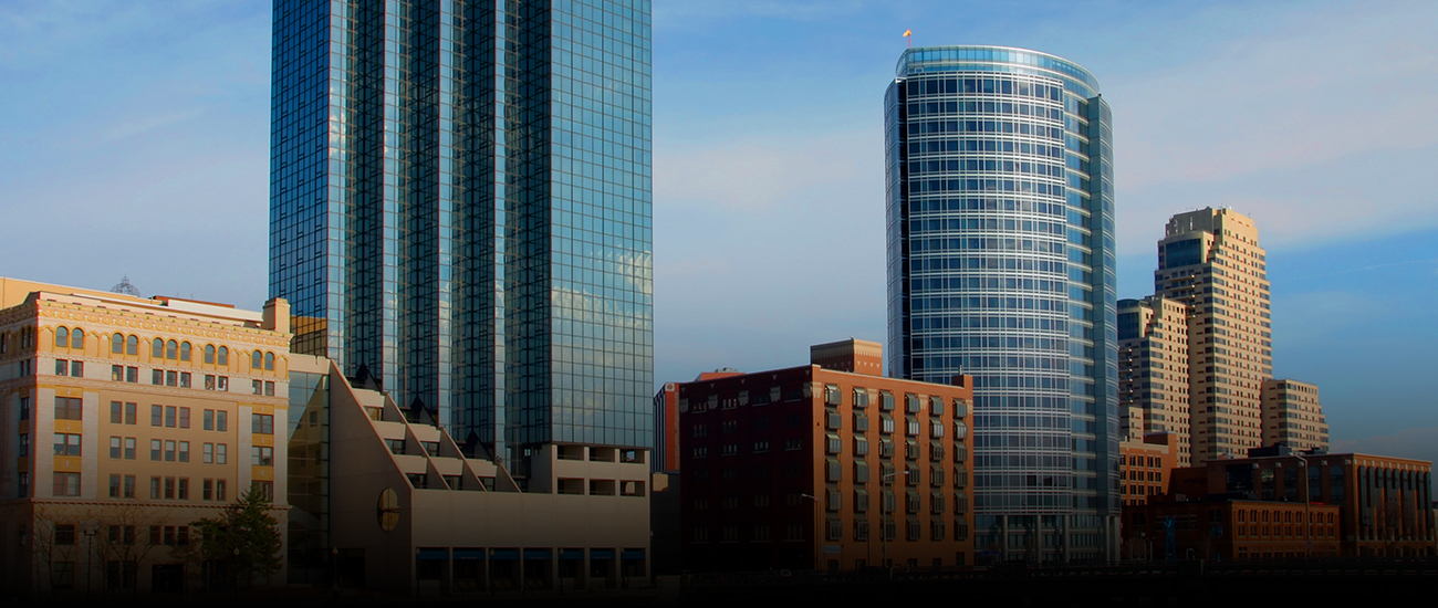 A panoramic view of the downtown Minneapolis skyline with tall buildings and a clear blue sky