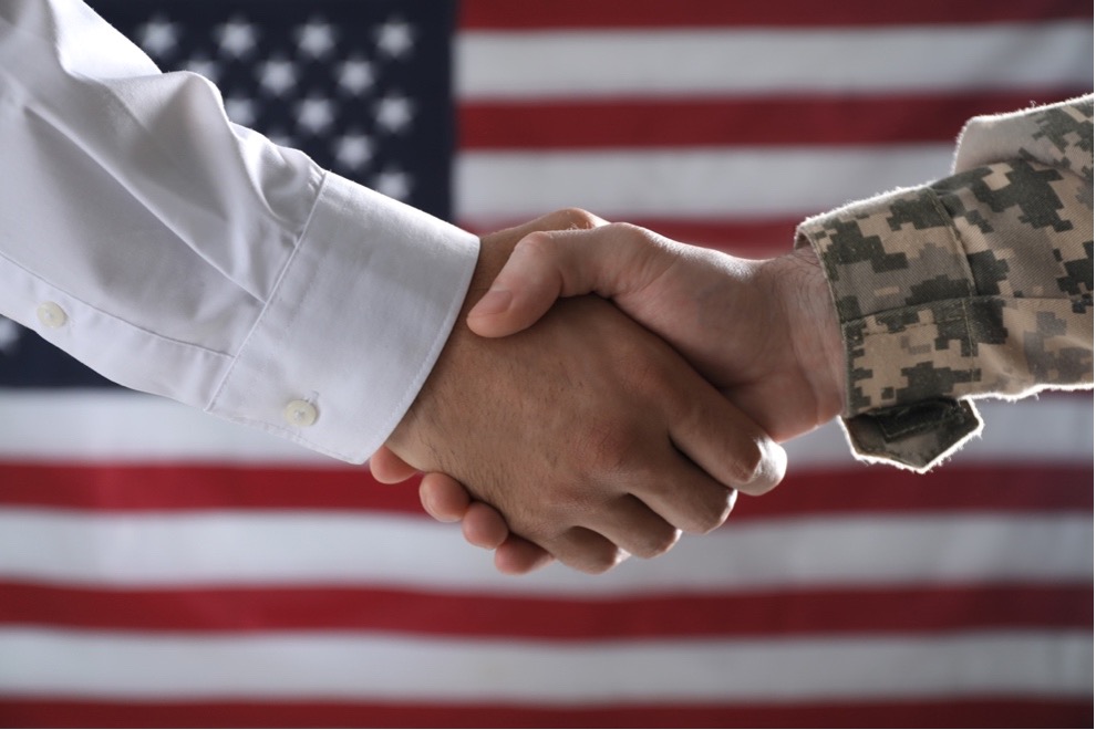 Two Men Shaking Hands in Front of a U.S. Flag